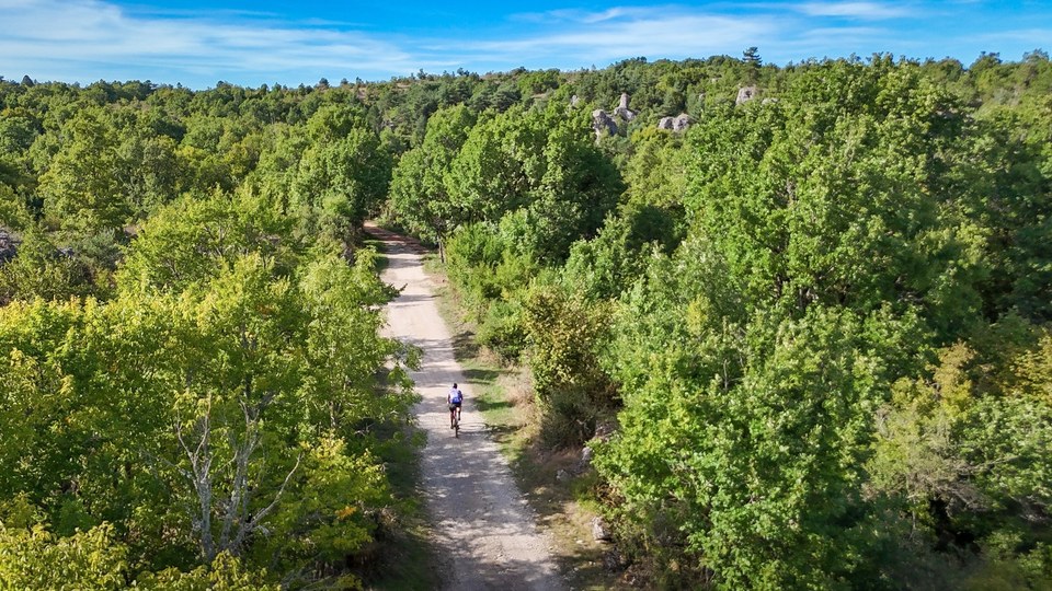 Cycliste gravel sur belle piste du larzac près du Cros